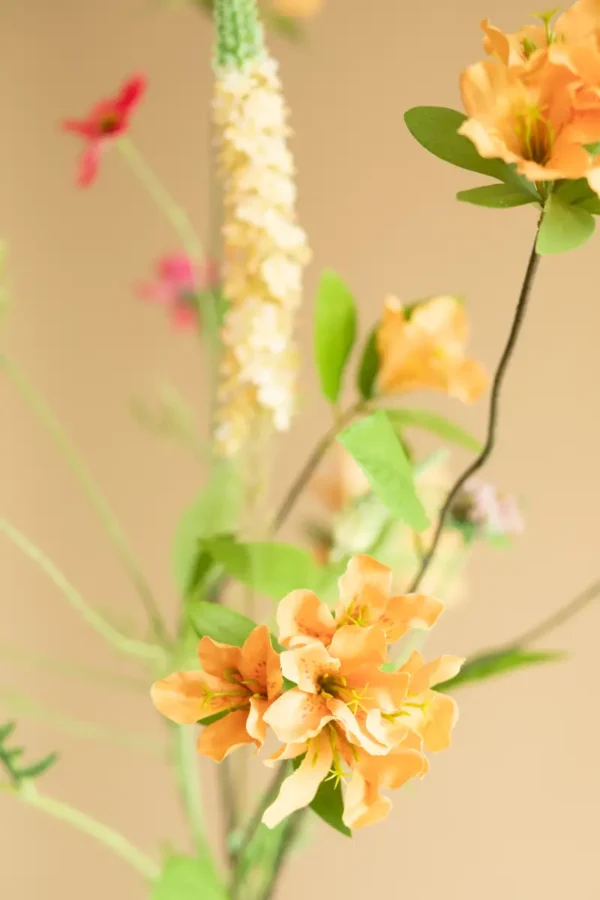 Close up of Jula Bloom’s Coco silk flower bouquet with orange, yellow and pink blooms