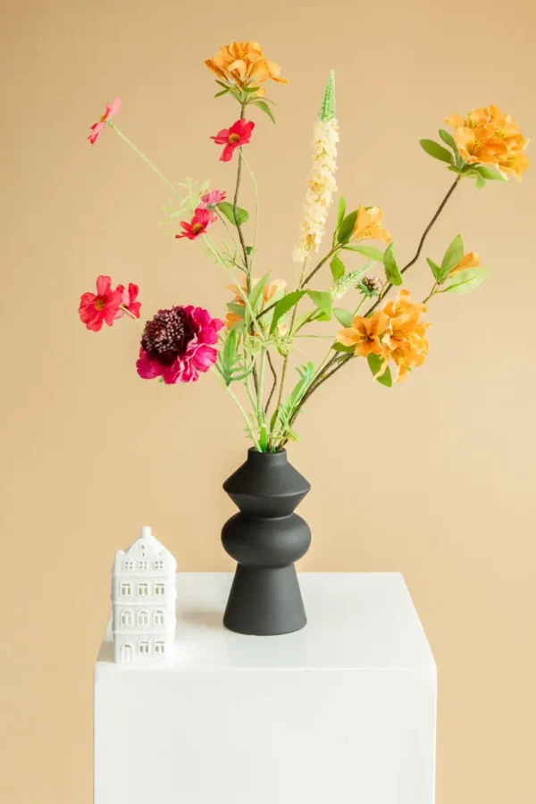 Jula Bloom’s Coco silk flower bouquet with orange, yellow and pink blooms, in a black vase