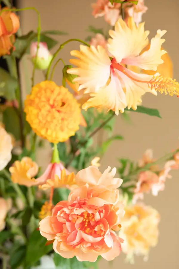 Close up of Jula Bloom’s Curie silk flower bouquet with peach and orange blooms