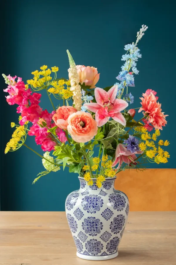 Jula Bloom’s Lovelace silk flower bouquet with multi-colored blooms, in a traditional white and blue painted vase