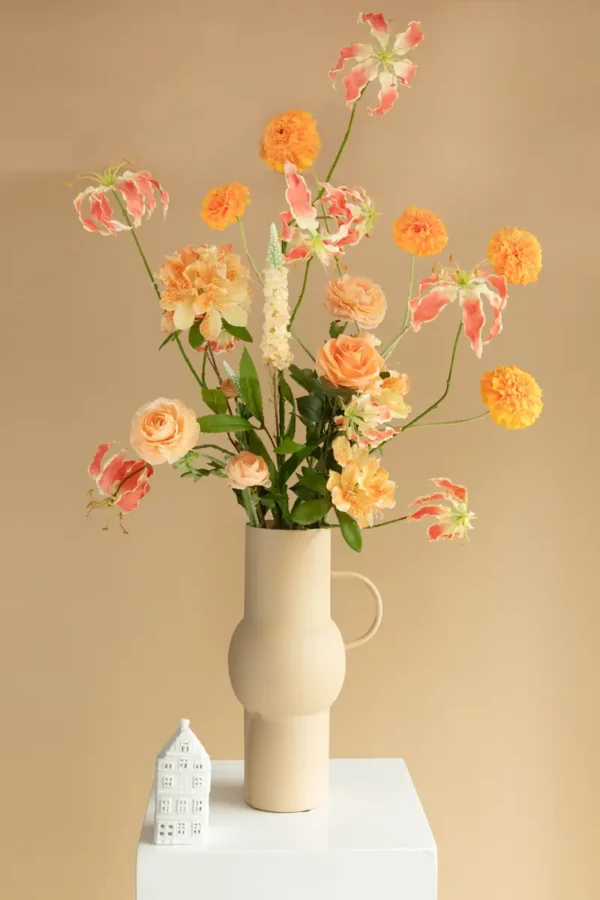 Jula Bloom’s Arc silk flower bouquet with orange and peach blooms, in a white vase with handle