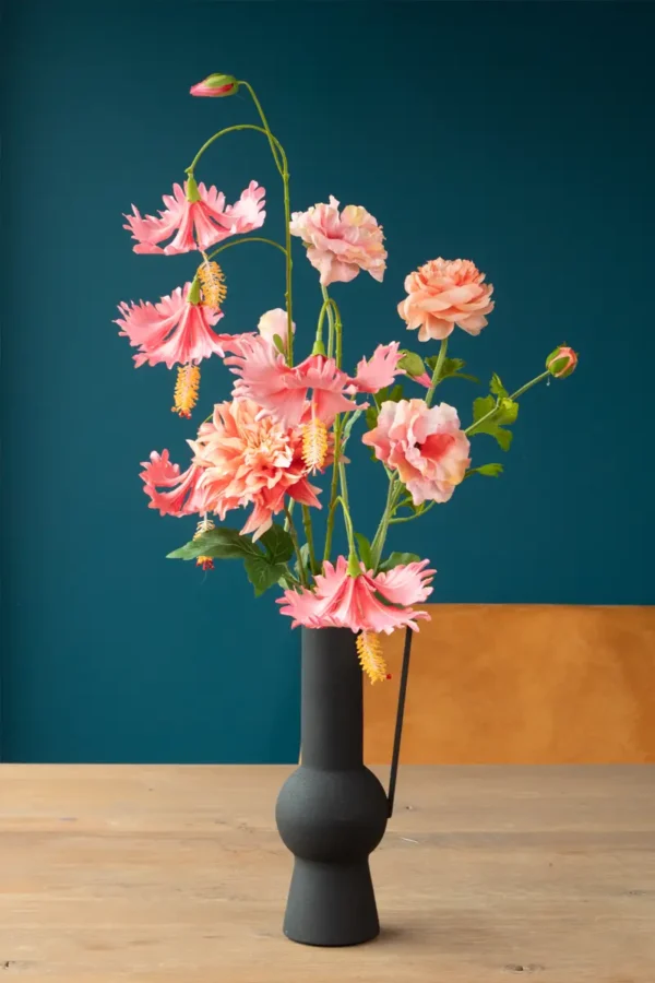 Jula Bloom’s Coco silk flower bouquet with pink and peach blooms, in a black vase with handle