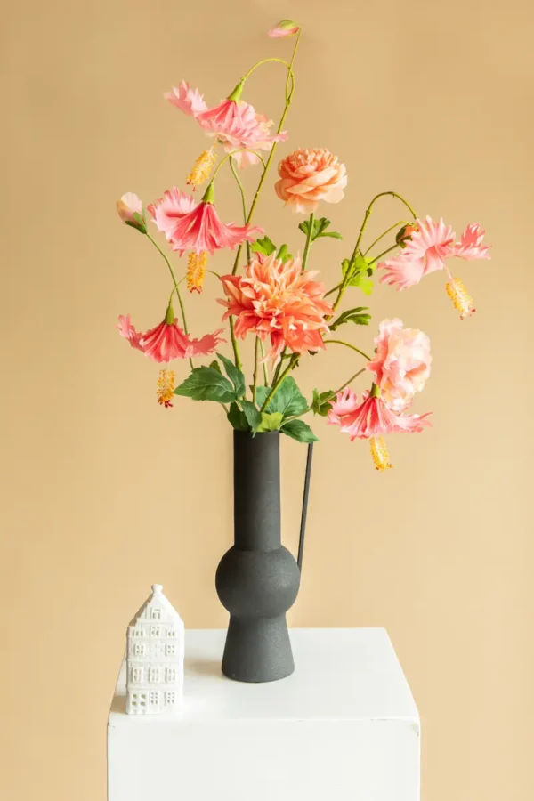 Jula Bloom’s Coco silk flower bouquet with pink and peach blooms, in a black vase with handle