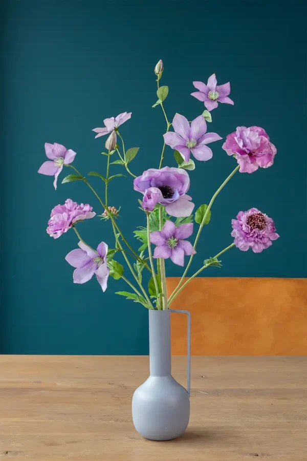 Jula Bloom’s Juliana silk flower bouquet with purple blooms in agrey vase on a wooden counter