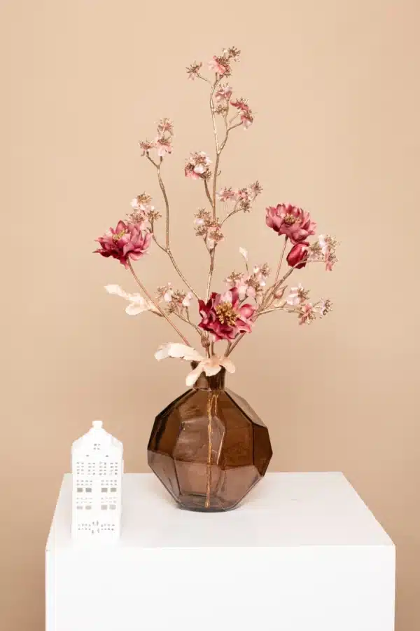 Jula Bloom’s Austen silk flower bouquet with pink blooms and gold brances, in a opaque brown vase, on a white pillar