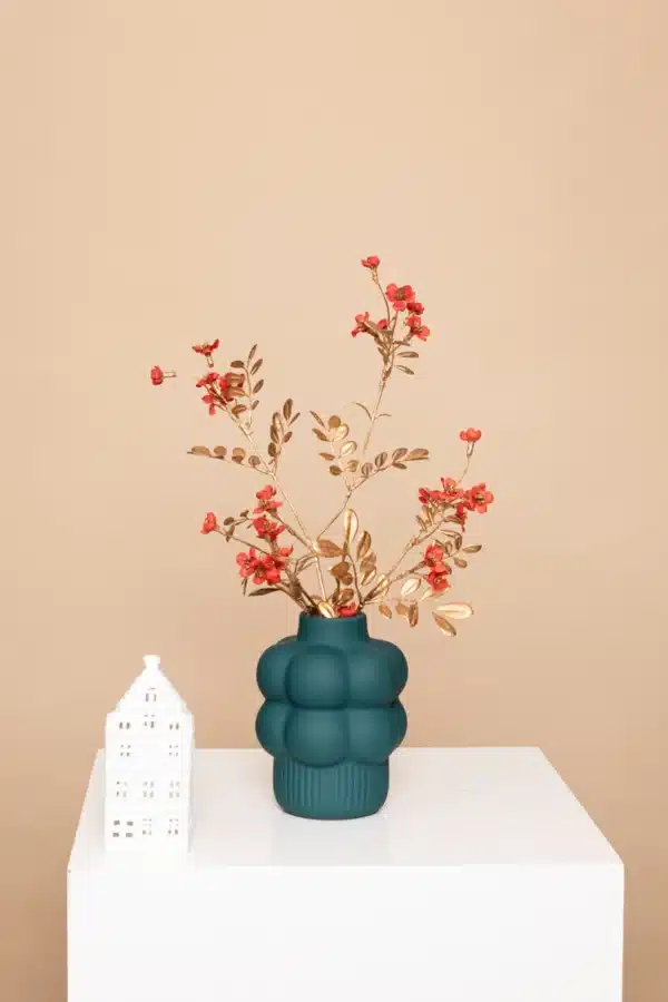 Jula Bloom’s Franklin silk flower bouquet with red blooms and gold leaf, in a green vase on a white pillar