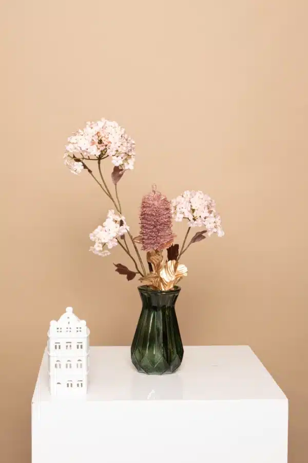 Jula Bloom’s Sanger silk flower bouquet with pink blooms and gold leaf, in a clear opaque green vase on a white pillar